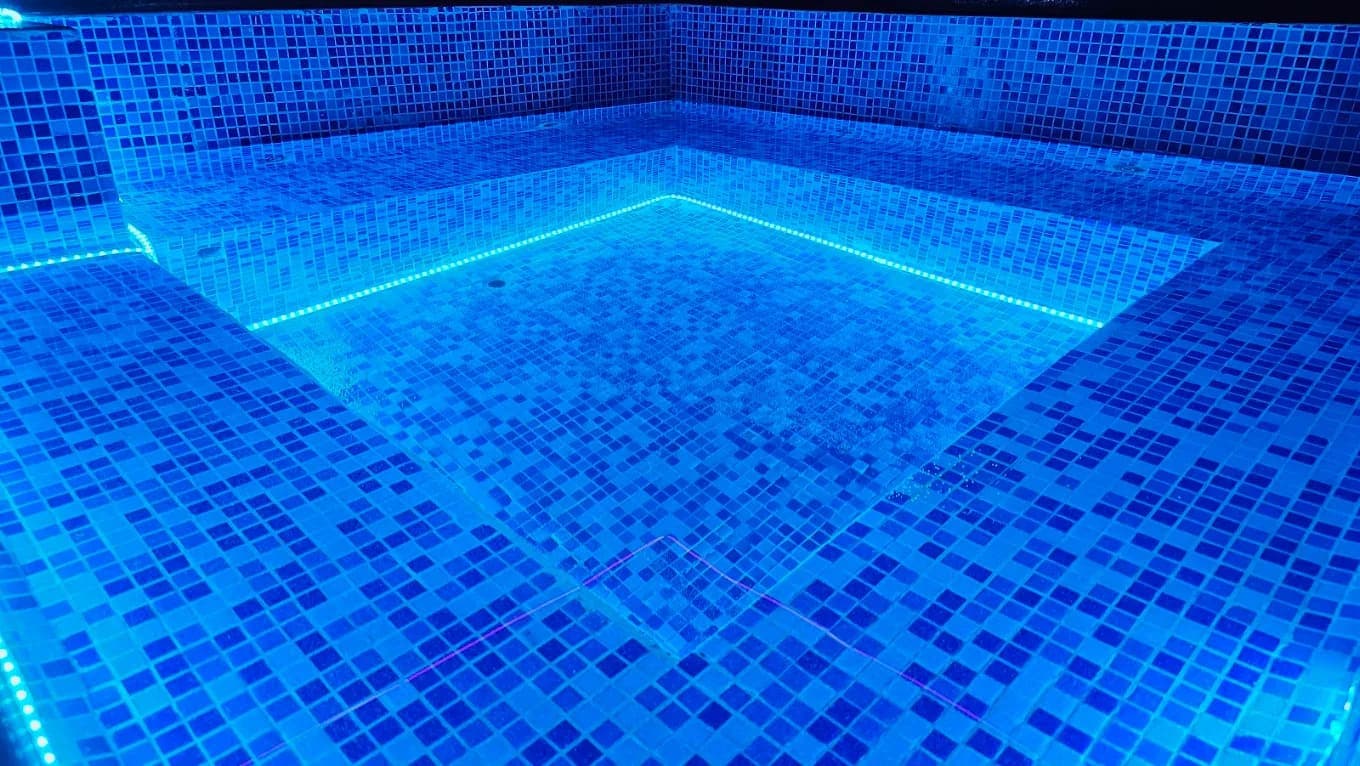 El Baño de Poseidón (jacuzzi) vacío, con cromoterapia violeta sobre el agua